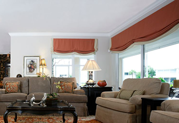 Modern living area adorned with vibrant orange Roman shades